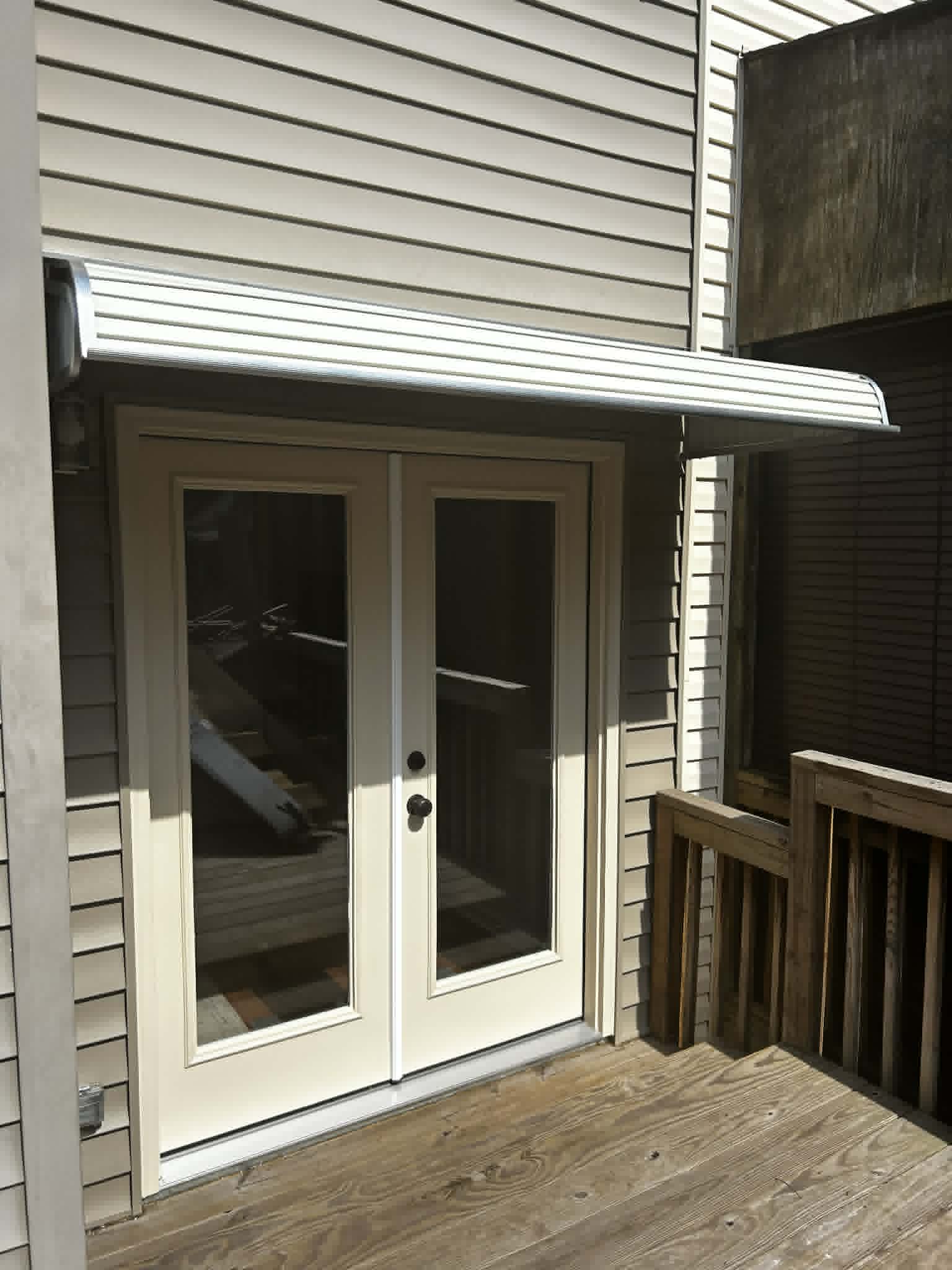 New exterior front door with metal awning over the entryway.